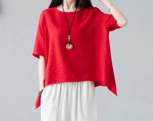Woman wearing red asymmetrical loose top with short sleeves and crew neck