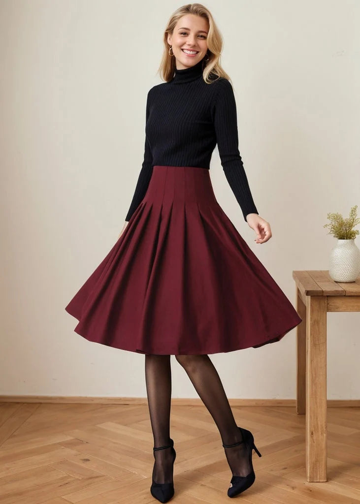 May include: A maroon high-waisted skirt with pleats. The skirt is knee-length and has a flared silhouette.